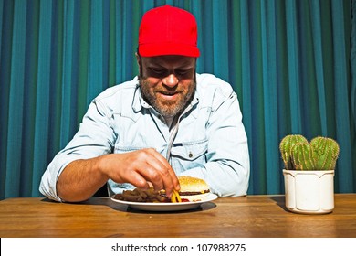 Man With Beard Eating Fast Food Meal. Enjoying French Fries And A Hamburger. Trucker With Red Cap.