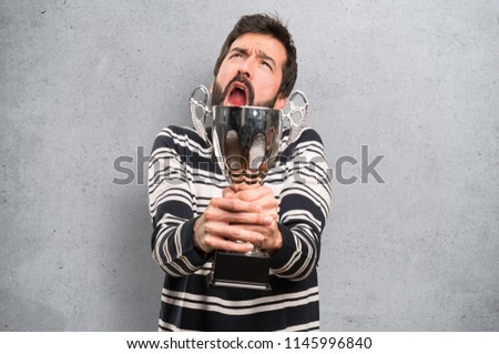 Man with beard holding a trophy on textured background