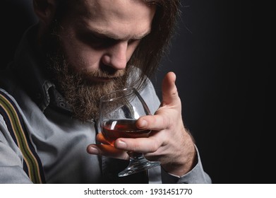 Man With Beard Holds Glass Brandy. Bearded Drink Cognac. Sommelier Tastes Drink. Man Holding A Glass Of Whisky. Sipping Whiskey.