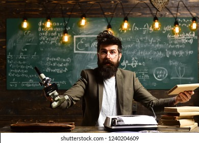 Man with beard and mustache in university. Bearded man with book and retro typewriter. Scientist make research with microscope. Businessman wear glasses at desk. Research or knowledge and innovation.