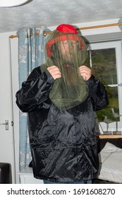 Man with beard, rainwear and mosquito net