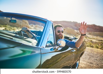 Man With Beard Sitting In Vintage Car Waving