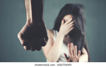 man beat sad woman on dark background - Shutterstock ID 1032754393