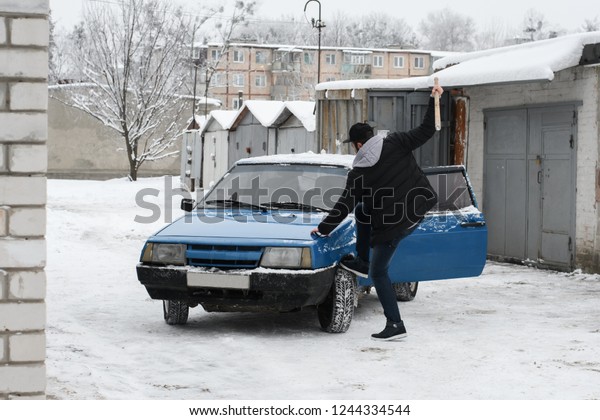 man beats the\
car with a bat.old russian\
car
