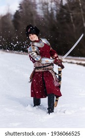 The Man Beats With A Saber In The Snow Is Dressed In The Costume Of The Grand Duchy Of Lithuania. Reconstruction Of A Historical Event. Szlachta