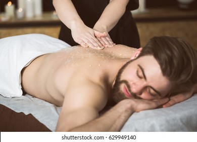 Man At Beautician's Getting An Exfoliating Massage With Salt Peeling