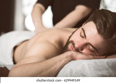 Man At Beautician's Getting An Exfoliating Massage With Salt Peeling