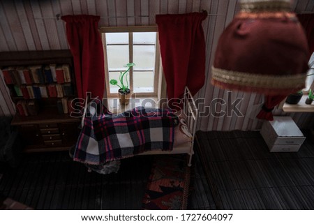 Man in bed during day time. A realistic dollhouse bedroom with furniture and window. Corona virus stay home be safe concept. Selective focus