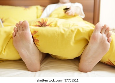 Man In Bed With TV Remote Control