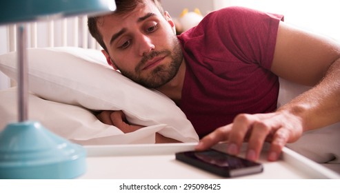 Man In Bed Woken By Alarm On Mobile Phone