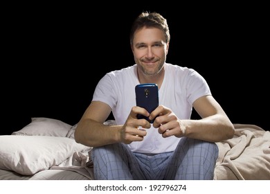 Man In Bedroom Using Cell Phone Late At Night 