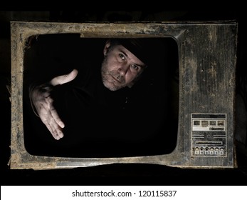 Man Behind TV Screen. A Man Behind The TV Screen In Dark Background That Wants To Handshake The Viewers