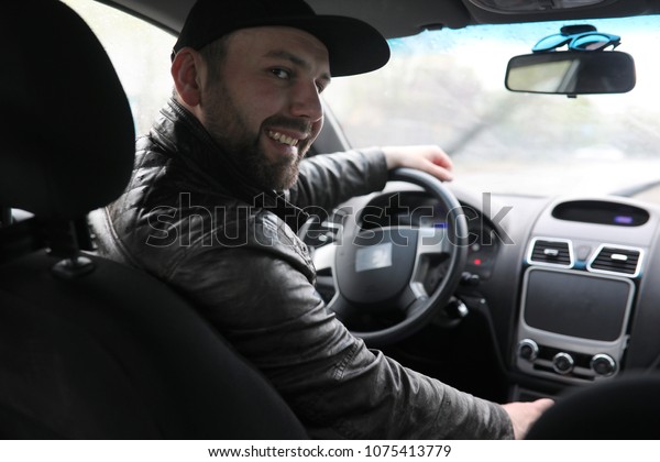 The man behind the wheel of a car while driving in\
rainy day\
