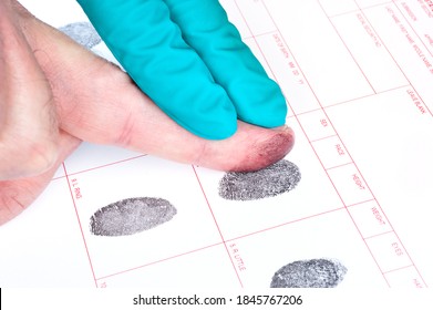 A man is being finger printed for either a crime of for FBI screening on a legal document form.