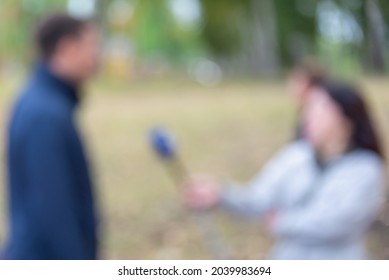 The man is being interviewed. Blurred.