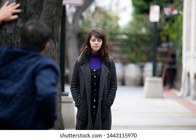 Man Being Rude, Leering And Cat Calling Or Sexually Harassing A Woman Walking On The Street.  Also Depicts Crime And Safety With A Stalker Following A Female Victim.  