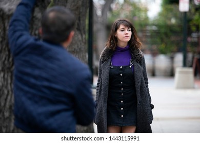Man Being Rude, Leering And Cat Calling Or Sexually Harassing A Woman Walking On The Street.  Also Depicts Crime And Safety With A Stalker Following A Female Victim.  
