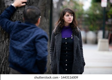 Man Being Rude, Leering And Cat Calling Or Sexually Harassing A Woman Walking On The Street.  Also Depicts Crime And Safety With A Stalker Following A Female Victim.  