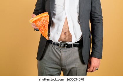 Man belly and pizza. Fat man with piece of pizza in hand. Obesity, junk food concept. Fat overweight guy hold pizza. Healthy and unhealthy nutrition. Fat man and fast food. Slice pizza in hand of man.