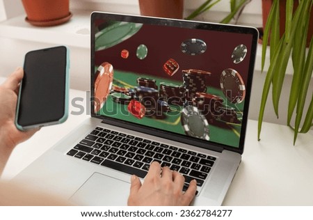 Man betting on sports using laptop at table, closeup. Bookmaker website on screen