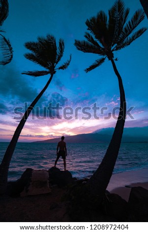 Man between two palms on the beach. Epic colorful sky. Hawaii, Philippines, Bali, Maledives. Oahu, Maui.