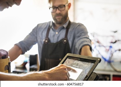 A Man In A Bicycle Repair Shop Using A Laptop Computer Running A Business