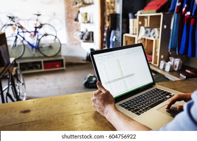 A man in a bicycle repair shop using a laptop computer Running a business - Powered by Shutterstock