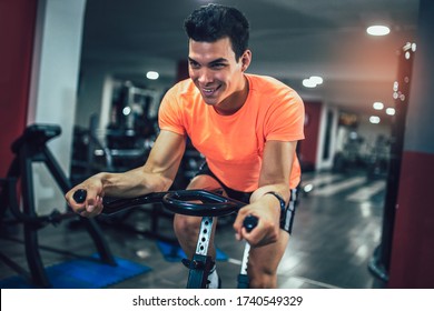 Man biking in the gym, exercising legs doing cardio workout cycling bikes. - Powered by Shutterstock