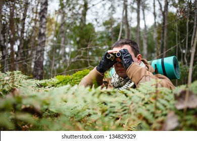 Man with binoculars at a forest. - Powered by Shutterstock