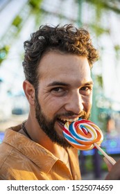 Man Biting Lollypop At Funfair