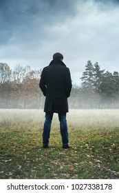 A man in a black coat in foggy weather