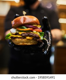 Man Black Gloves Holding Burger Hands Juicy Burger Close Appetizing burger. - Shutterstock ID 1958591491
