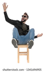 Man In Black Jacket And Blue Jeans Falling From Chair While Screaming On White Background