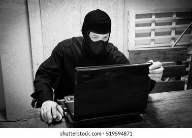 Man In Black Mask With Computer,Dangerous  Terrorist Concept