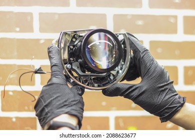 A Man In Black Rubber Gloves Holds The LED Lens Of A Car Headlight. Car Repair And Tuning. Headlight Repair. Restoration Of Automotive Optics.