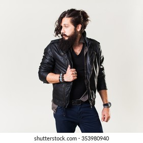 Man Black Shirt And Pants In Leather Jacket With A Beard And Mustache Posing In The Studio On A White Background, The Macho Male Muscular Guy, Handsome Brutal Man Movie Star Fashionable Clothes