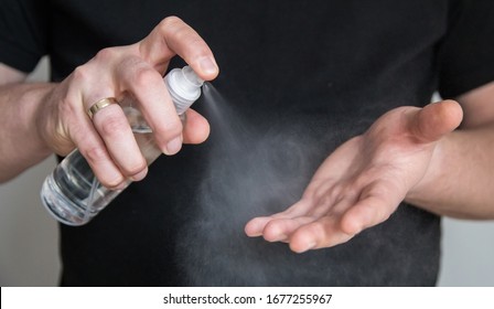 Man In Black Shirt Spraying Hand Sanitizer,close Up.