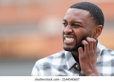 Man With Black Skin Scratching Itchy Beard In The Street