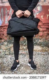 A Man With A Black Sports Bag In His Hands.