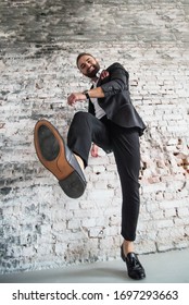 Man In Black Suit 
On A  Brick Background Make Big Step