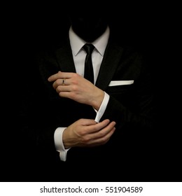 Man in a black suit and white shirt and black tie on a black background. Without a face. The businessman in the dark. Studio shot - Shutterstock ID 551904589
