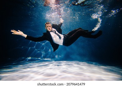 Man In Black Suite Swimming In A Pool. Business Man Having Fun In A Pool. Office Worker Drowing And Sinking In A Pool