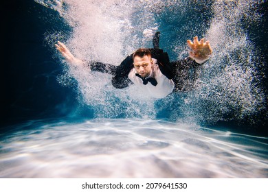 Man in black suite swimming in a pool. business man having fun in a pool. Office Worker drowing and sinking in a pool