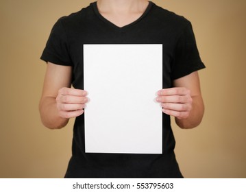 Man In Black T Shirt Holding Blank White A4 Paper. Leaflet Presentation. Pamphlet Hold Hands. Man Show Clear Offset Paper. Sheet Template.