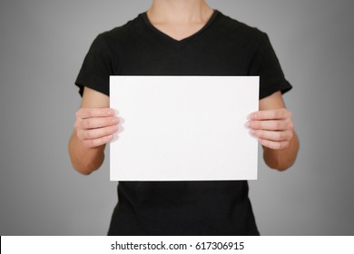 Man In Black T Shirt Holding Blank White A4 Paper. Leaflet Presentation. Pamphlet Hold Hands. Man Show Clear Offset Paper. Sheet Template.