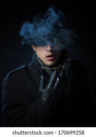 Man In The Black Trench Coat Smoking Electronic Hookah Pen In The Darkness