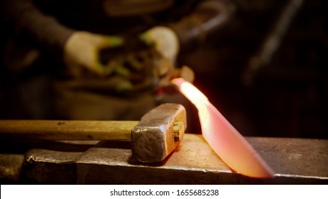 A man blacksmith making a knife out of metal - Powered by Shutterstock