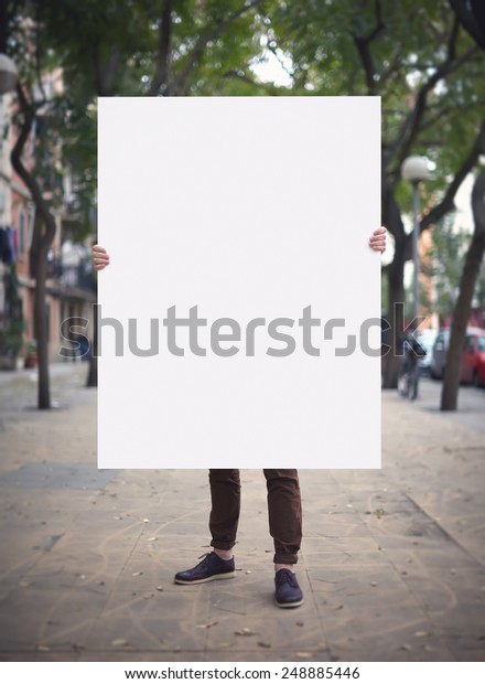 Man with blank poster on a\
street