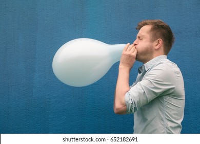Man blowing up a balloon
