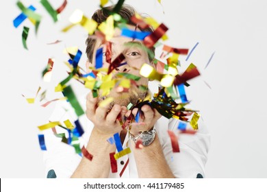 Man Blowing Confetti At Camera, Studio